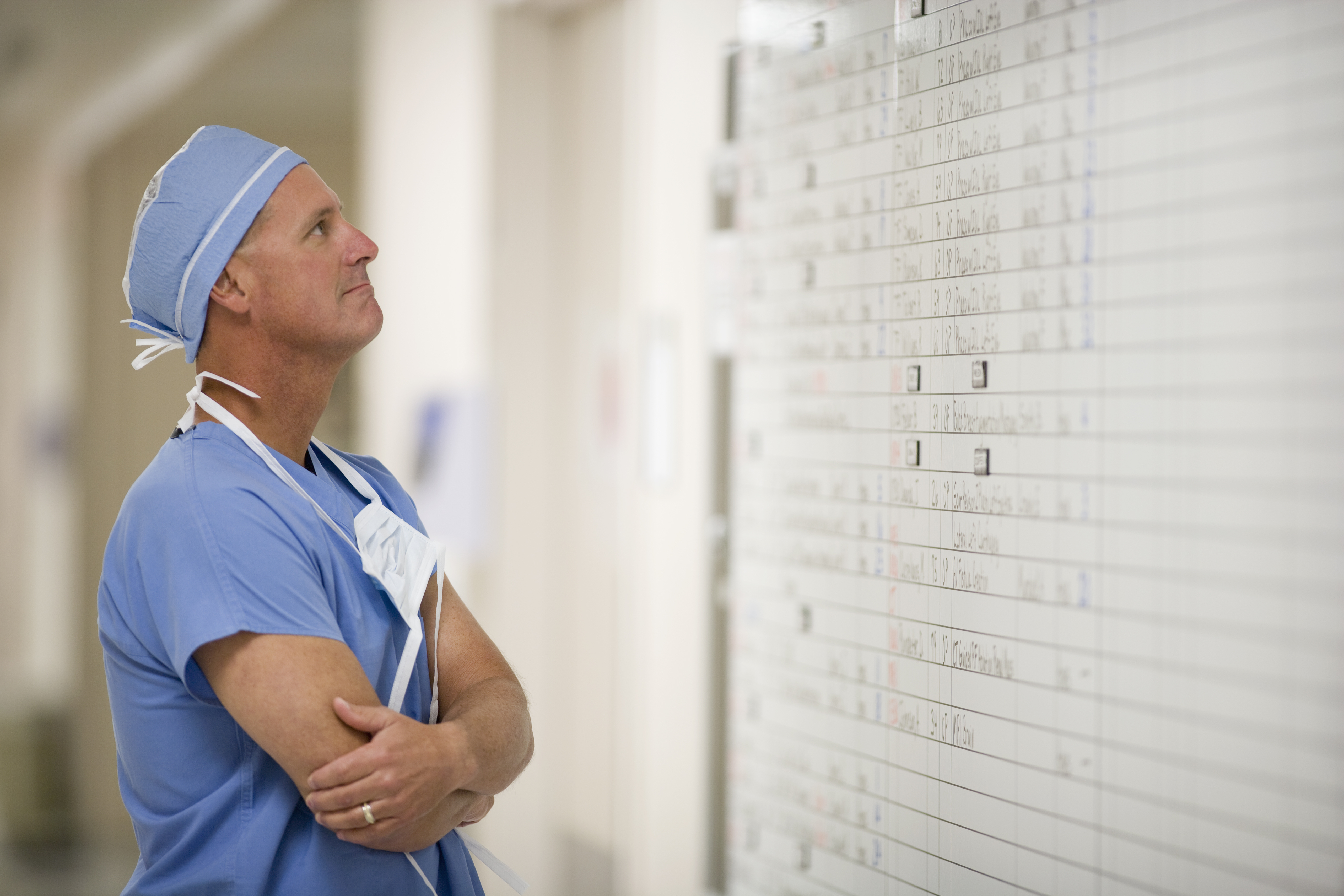 Doctor looking at schedule whiteboard in hospital