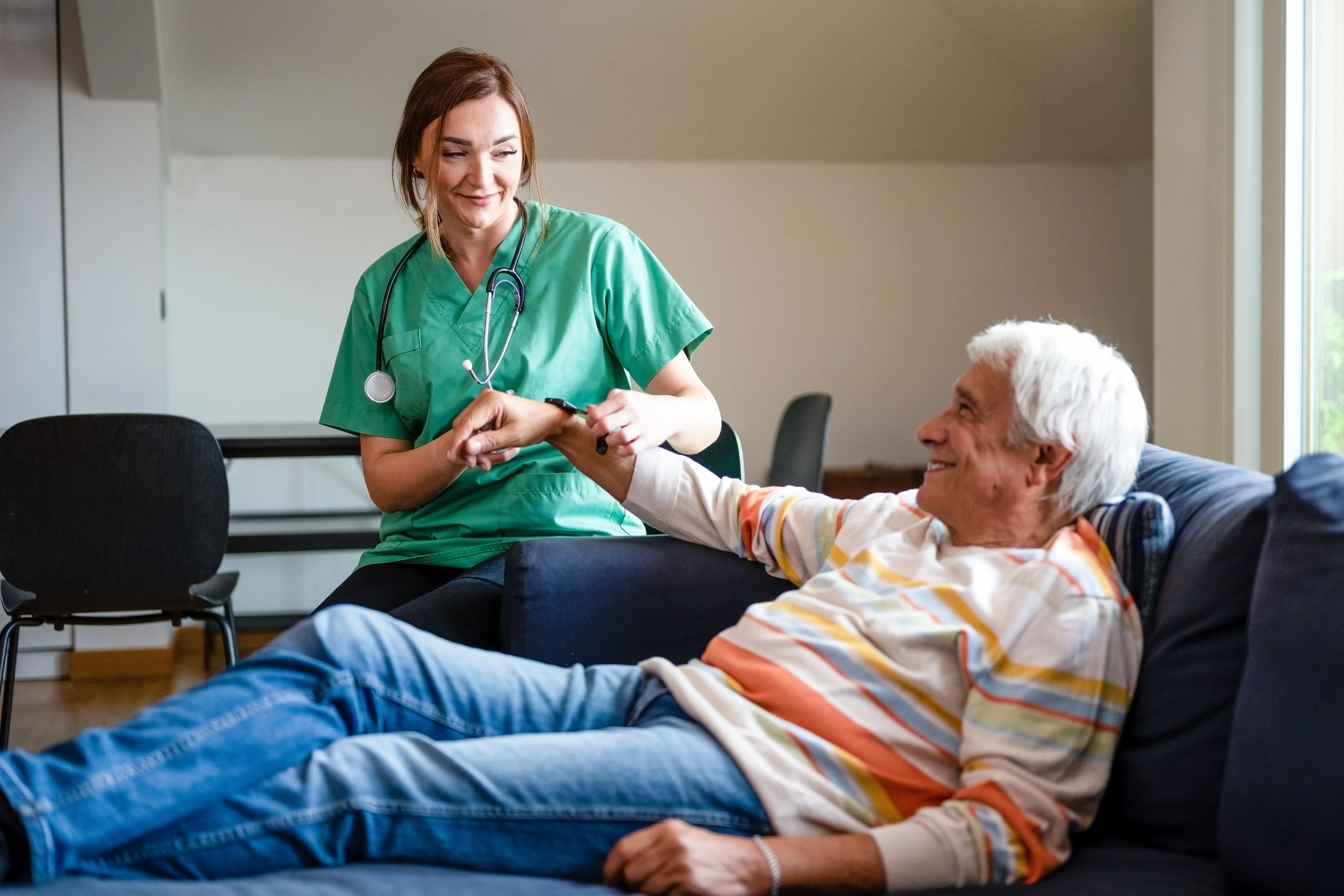 Female doctor of the medical health system putting a smartwatch on a old man, nurse helping senior man with modern smart watch and showing functions, smartwatch for assisted living concept